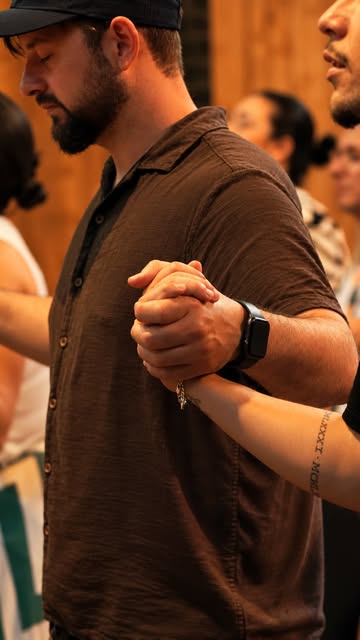 Two people clasp hands together in prayer