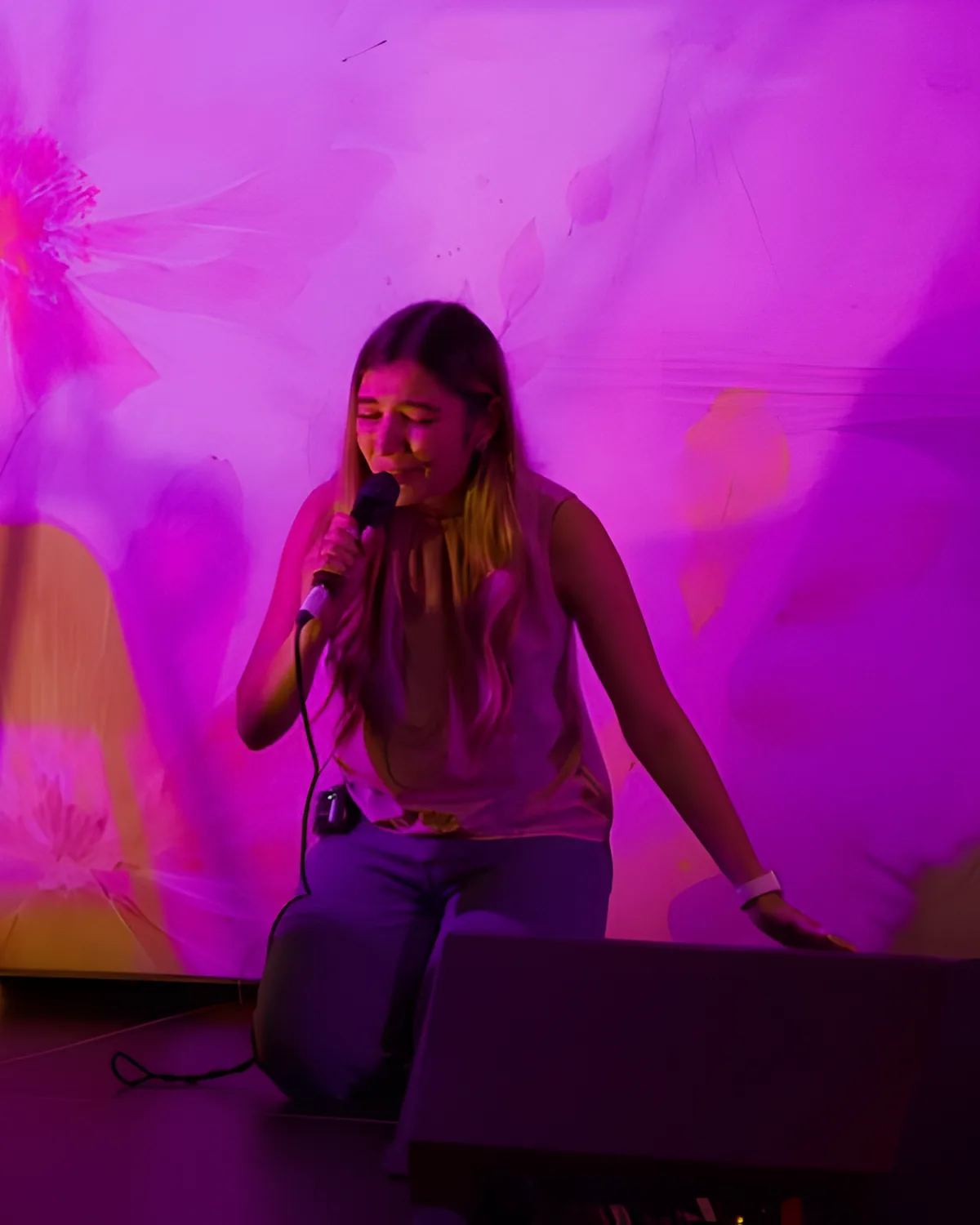 A woman sings into a microphone at an Accepted Ladies night