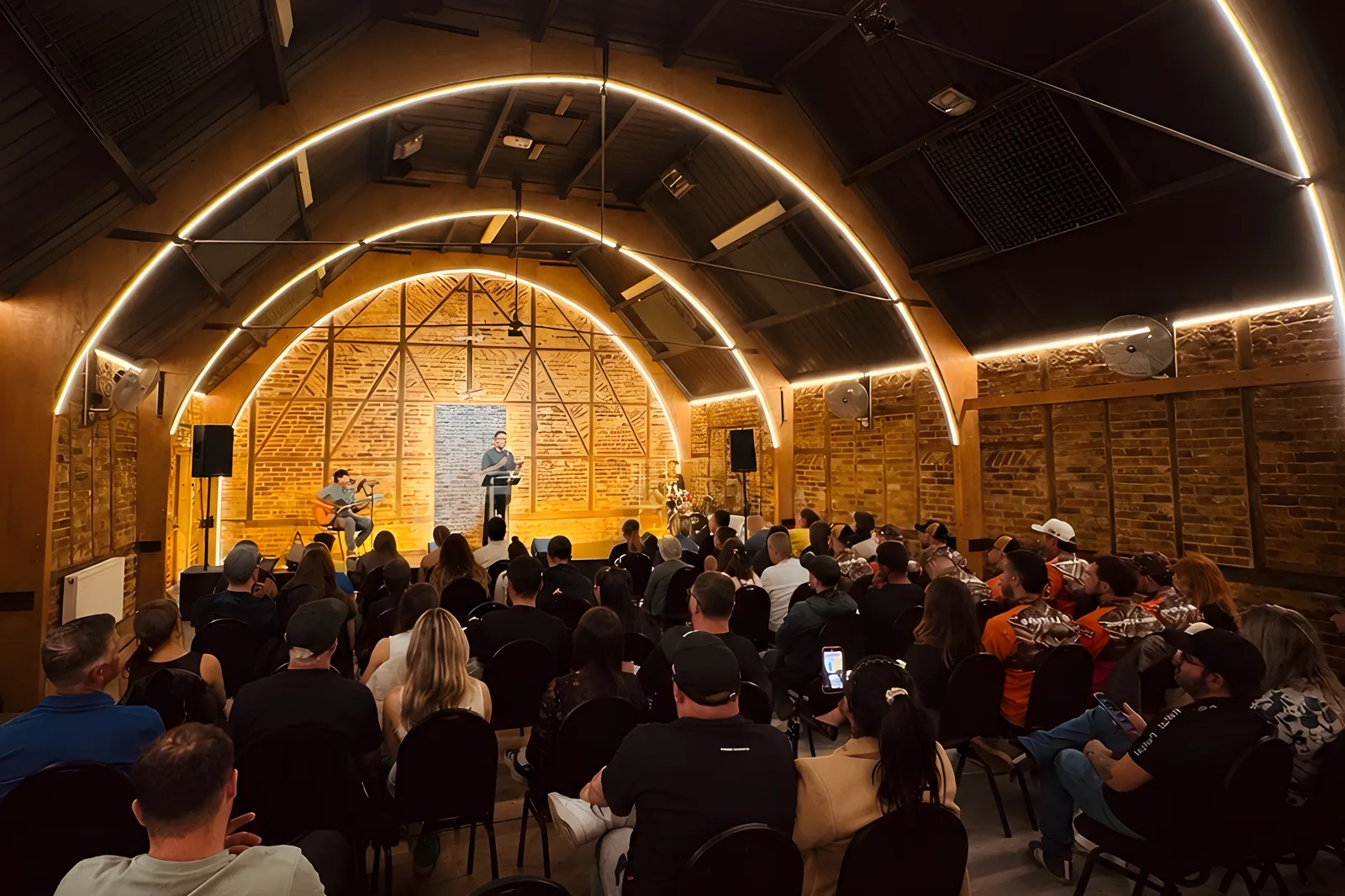 The congregation facing the stage under the lit arches at Hillside Church